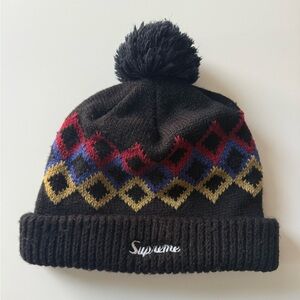 Black patterned Supreme Beanie. Argyle type pattern with pom
